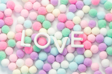 Love alphabet with pastel color pom pom background, valentine's day concept.