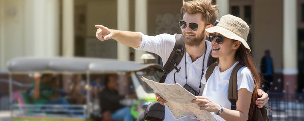 Fototapeta na wymiar Banner and web page or cover template of Multiethnic Travellers are looking the destination and holding the map at the train station, Travel and transportation concept