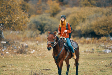 young woman riding a horse in nature