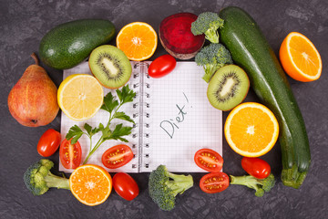 Notepad and fruits with vegetables containing vitamins and minerals, slimming and diet concept