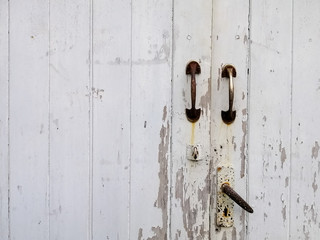 The texture of old white door and rusty door lock