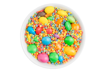 bowl filled with delicious multicolored candy isolated on white background top view