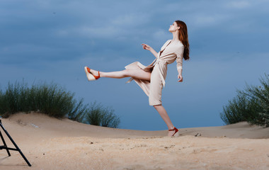 woman in dress runs along the sand ashore summer fashion style