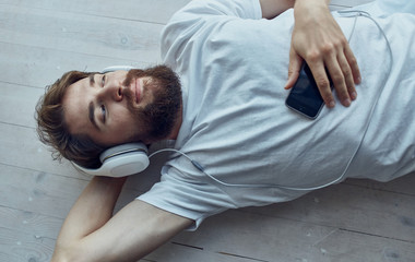 man resting listening to music on headphones