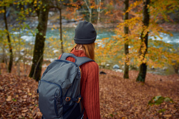 woman looks at the river autumn forest nature trip