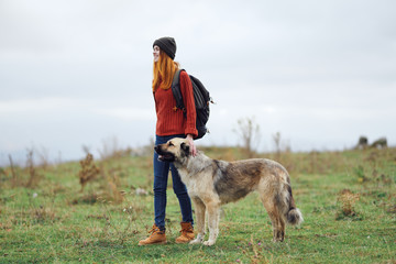 woman walking with a dog in nature