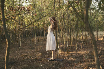 woman in a white sundress in nature in the trees village summer vacation