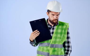 a builder in a helmet with documents thinks