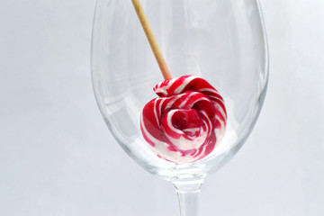 red lollipop in a glass, on a white background.