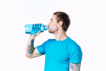 man with tattoo on his arm drinking water sport
