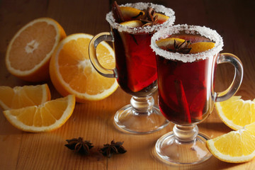 Two cups with ready mulled wine with anise, cinnamon and nuts around