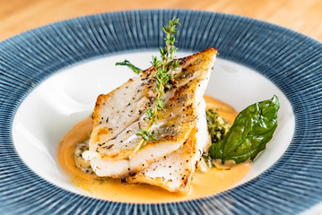 Fried fish fillet. Cod with sauce and herbs