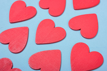 Red wooden hearts on blue paper. Romantic background
