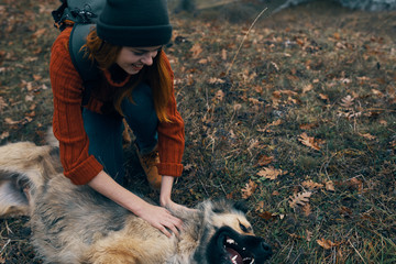 woman playing with a dog in nature