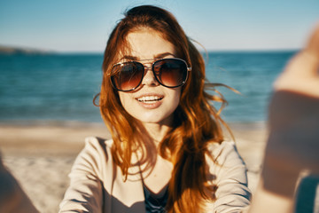 beautiful woman in sunglasses on the background of the sea