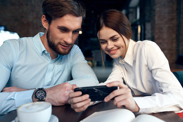 business colleagues in a cafe look into the phone