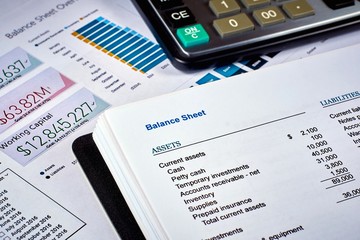 balance sheet and calculator on the background of financial documents, close-up