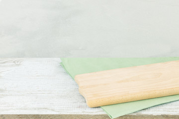 Napkin cloth and cutting board on gray wooden table.