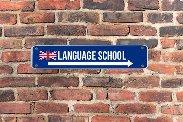 Fototapeta premium Ein Schild an der Wand weist auf die Sprachschule für englische Sprache hin