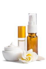 Beautiful flowers and bottles with natural skincare cream isolated on white background