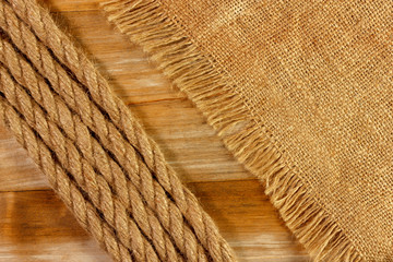 Natural fiber rope and fabric on a wooden textured background from an old plank.