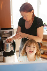 Mother and daughter making bread together at home kitchen