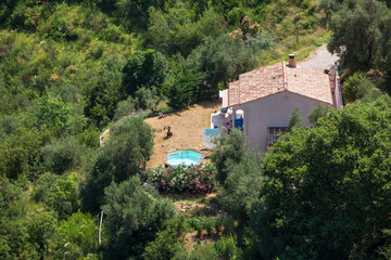 A small French house and swinmming pool as seen from above near the hilltop village of Sainte Agnes, south of France