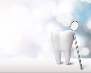 Grande dent et miroir de dentiste sur table