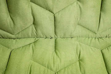 Close-up comfortable green soft sofa with curly stitching. Modern design