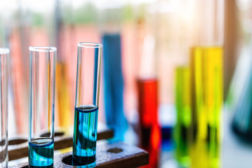 Lab glassware containing chemical liquid with laboratory background, science research and development concept 
