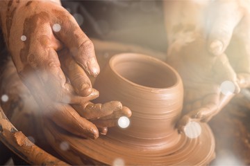 Hands of potter making clay pot, closeup photo