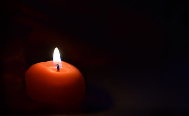 Red burning candle against dark or black background to celebration 