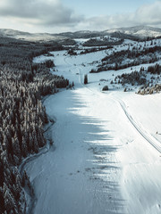 Scenic aerial view of the Carpathian mountains and forest in wintertime. The trees are covered with snow