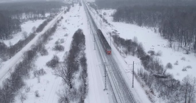 Passenger train an electric locomotive by Trans Siberian two-sided railway in winter frozen cloudy day - Aerial view