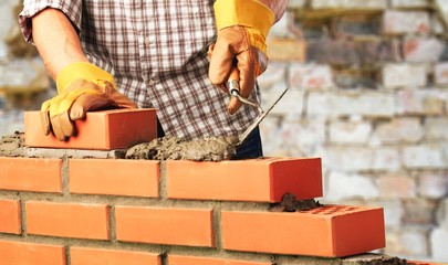 Worker builds a brick wall