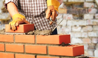 Worker builds a brick wall
