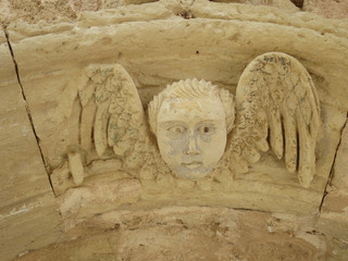 sculpture of an angel with wings above a door in Puglia Italy