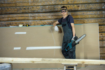 Industrial construction worker, professional carpenter cutting timber wood with chainsaw.