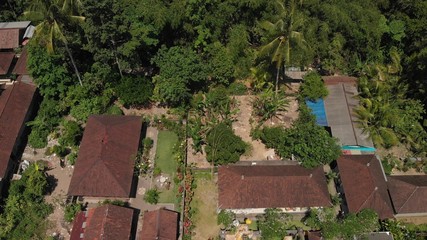4K aerial view of traditional balinese houses. Flying over balinese village. Bali island.