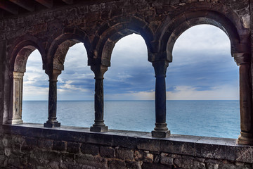 View through columns of Church of St. Peter in Portovenere or Porto Venere town on Ligurian coast. Italy