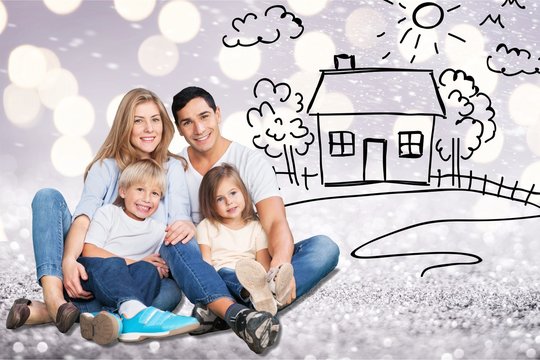 Beautiful smiling lovely family and drawing house in garden