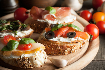 Italian tomato and cheese bruschetta. Tapas, antipasti with chopped vegetables, herbs and oil on grilled ciabatta and baguette bread.