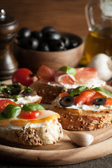 Italian tomato and cheese bruschetta. Tapas, antipasti with chopped vegetables, herbs and oil on grilled ciabatta and baguette bread.