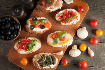 Italian tomato and cheese bruschetta. Tapas, antipasti with chopped vegetables, herbs and oil on grilled ciabatta and baguette bread.