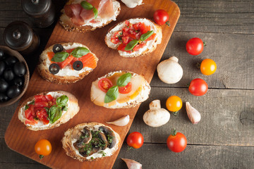 Italian tomato and cheese bruschetta. Tapas, antipasti with chopped vegetables, herbs and oil on grilled ciabatta and baguette bread.