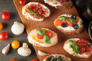 Italian tomato and cheese bruschetta. Tapas, antipasti with chopped vegetables, herbs and oil on grilled ciabatta and baguette bread.