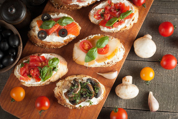 Italian tomato and cheese bruschetta. Tapas, antipasti with chopped vegetables, herbs and oil on grilled ciabatta and baguette bread.