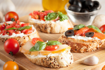 Italian tomato and cheese bruschetta. Tapas, antipasti with chopped vegetables, herbs and oil on grilled ciabatta and baguette bread.