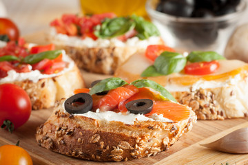 Italian tomato and cheese bruschetta. Tapas, antipasti with chopped vegetables, herbs and oil on grilled ciabatta and baguette bread.