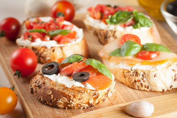 Italian tomato and cheese bruschetta. Tapas, antipasti with chopped vegetables, herbs and oil on grilled ciabatta and baguette bread.